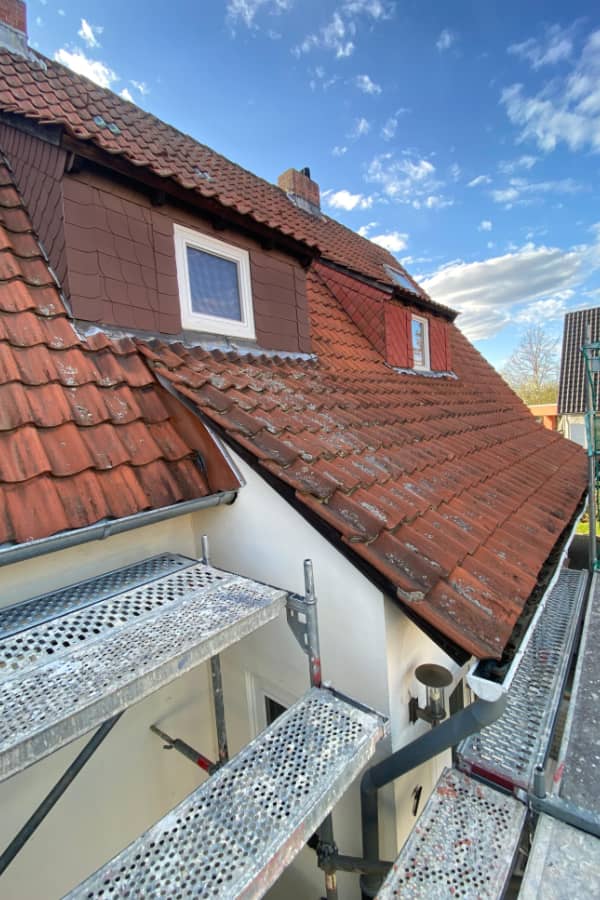 Bestandsdach einer Doppelhaushälfte vor der Sanierung mit gealterter Dacheindeckung und sanierungsbedürftigen Anschlüssen