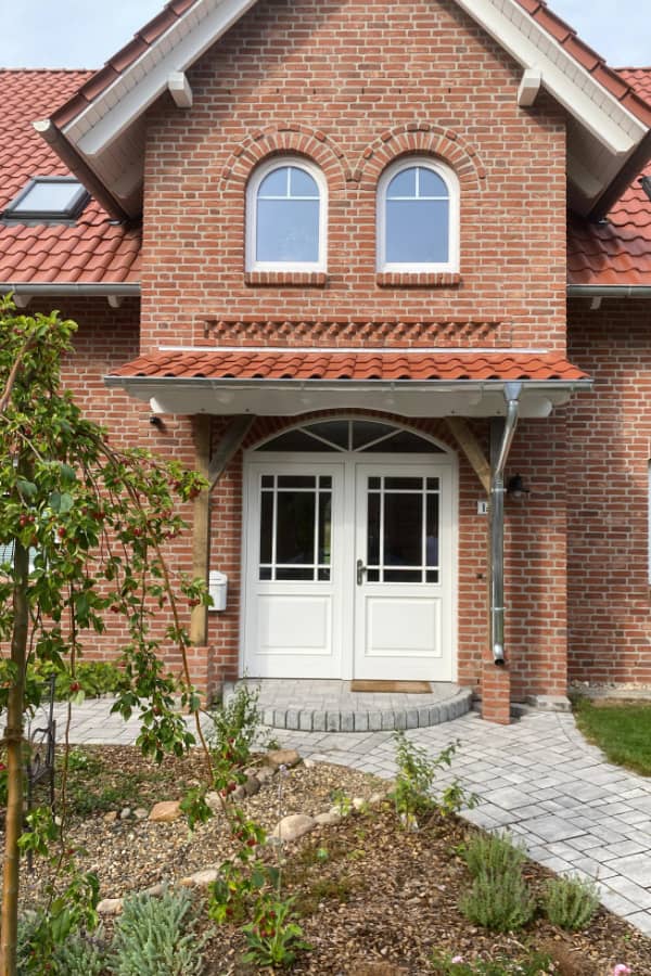 Neue Eingangsüberdachung aus Holz mit Ziegeldach, harmonisch abgestimmt auf die Architektur des Wohnhauses