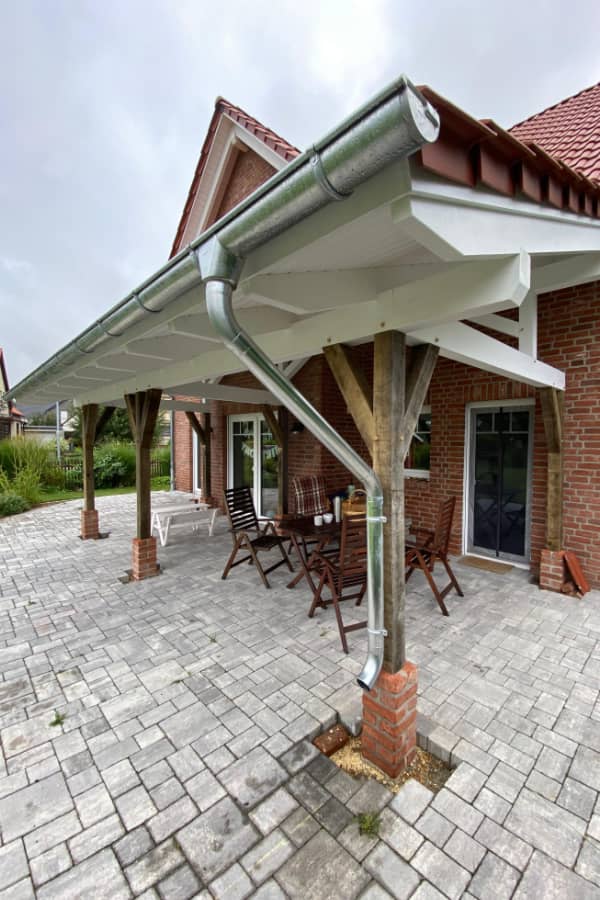 Fertiggestellte Terrassenüberdachung aus Holz mit Ziegeldach und hochwertiger handwerklicher Ausführung