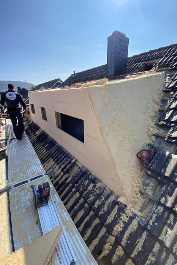 Nachträglicher Bau einer Trapezgaube während der Dacharbeiten mit vorbereiteter Außenhülle und Fensteröffnungen