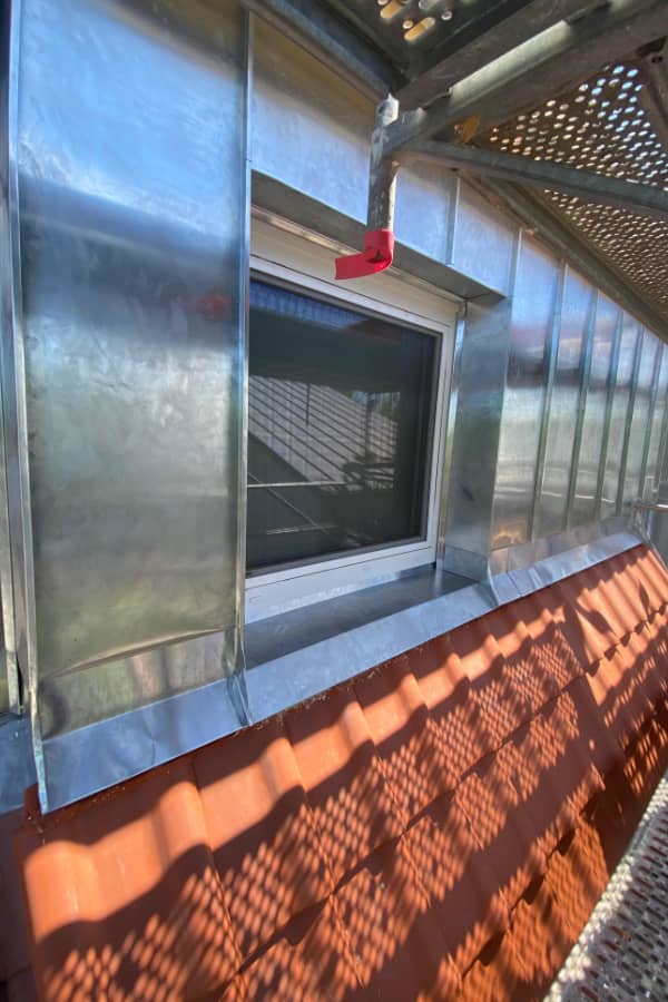 Detailansicht einer professionellen Spenglerarbeit am Dachfenster mit wetterfester Metallverkleidung und sauberer Abdichtung