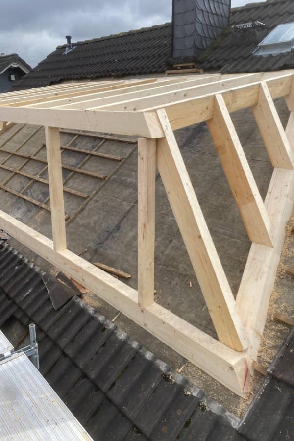 Holztragwerk einer Trapezgaube im Aufbau mit präziser Zimmererarbeit und passgenauer Konstruktion