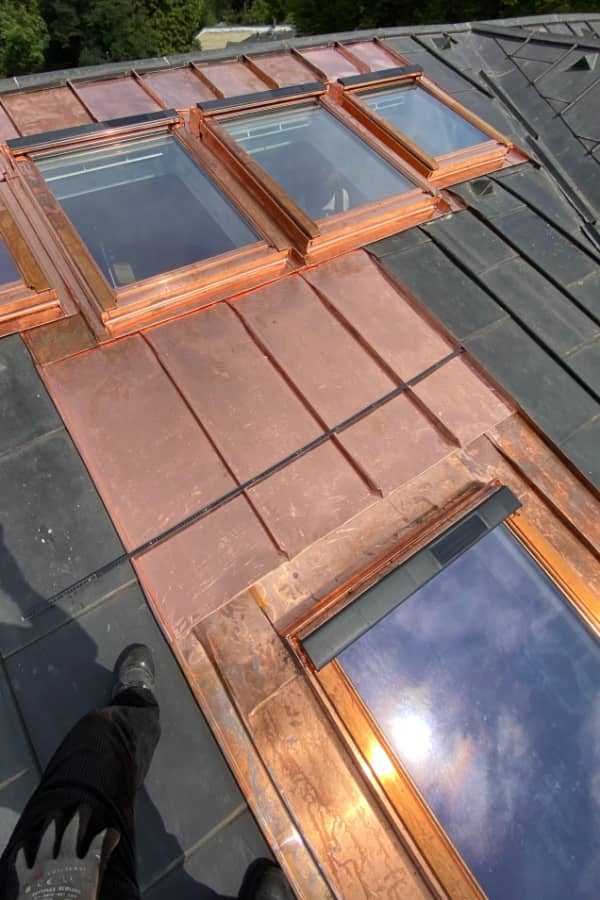 Detailansicht hochwertiger Kupfer-Spenglerarbeiten rund um moderne Velux-Dachflächenfenster