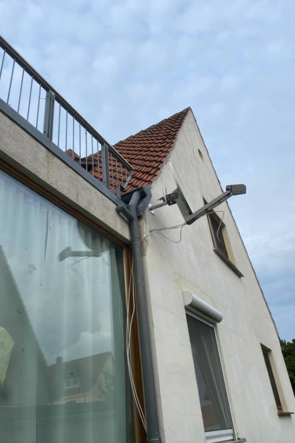 Außenansicht einer Doppelhaushälfte vor der Dachsanierung mit alter Dacheindeckung und ungedämmtem Dachbereich